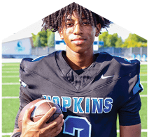 A young man wearing a white jersey with the number 10 on it. Description generated by AI