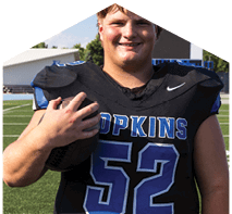 A young man wearing a white jersey with the number 10 on it. Description generated by AI