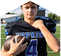 A young man wearing a white jersey with the number 10 on it. Description generated by AI