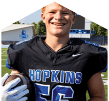 A young man wearing a white jersey with the number 10 on it. Description generated by AI