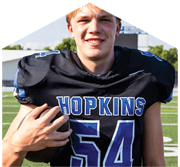 A young man wearing a white jersey with the number 10 on it. Description generated by AI