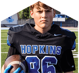 A young man wearing a white jersey with the number 10 on it. Description generated by AI
