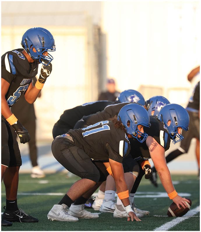 A group of football players wearing black and white uniforms. Description generated by AI