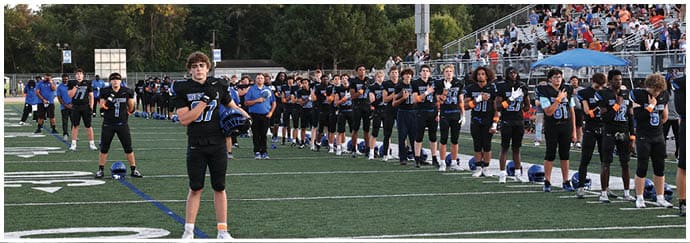 A group of football players on a field. Description generated by AI