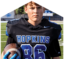 A young man wearing a white jersey with the number 10 on it. Description generated by AI