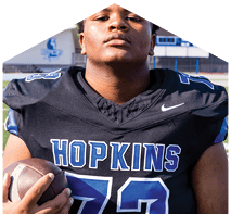 A young man wearing a white jersey with the number 10 on it. Description generated by AI