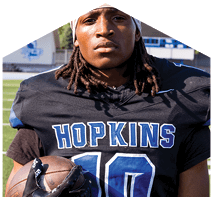 A young man wearing a white jersey with the number 10 on it. Description generated by AI
