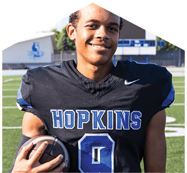 A young man wearing a white jersey with the number 10 on it. Description generated by AI