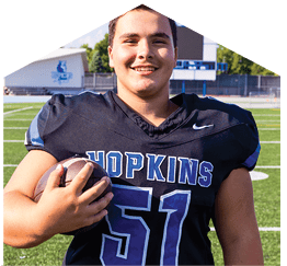 A young man wearing a white jersey with the number 10 on it. Description generated by AI