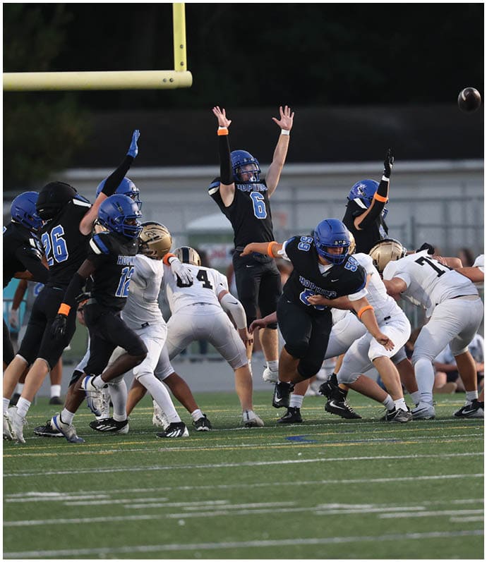A group of football players wearing black and white uniforms. Description generated by AI