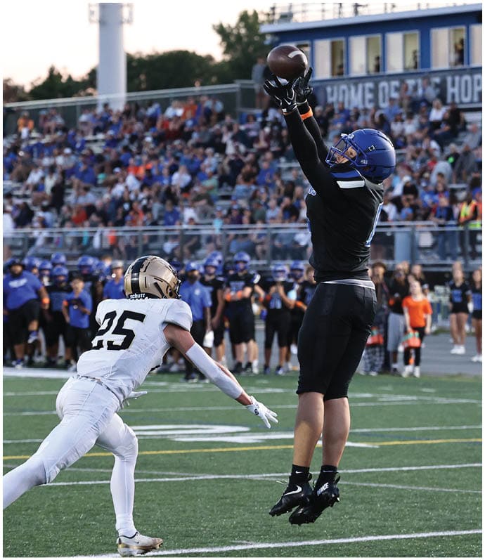 A group of football players wearing black and white uniforms. Description generated by AI