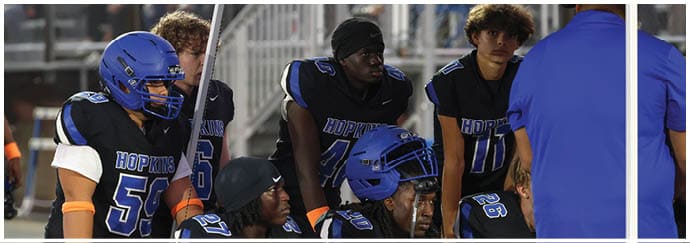 A group of football players on a field. Description generated by AI