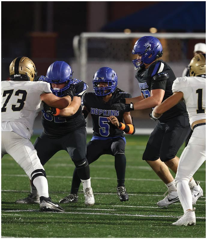 A group of football players wearing black and white uniforms. Description generated by AI