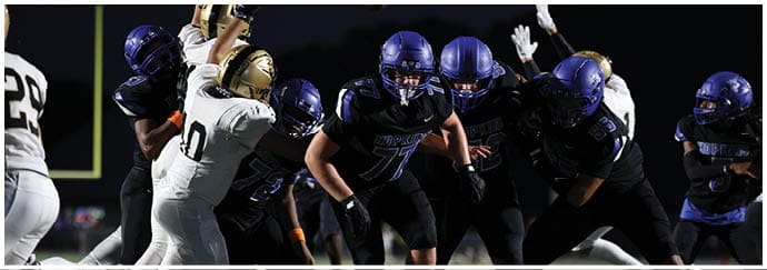 A group of football players on a field. Description generated by AI