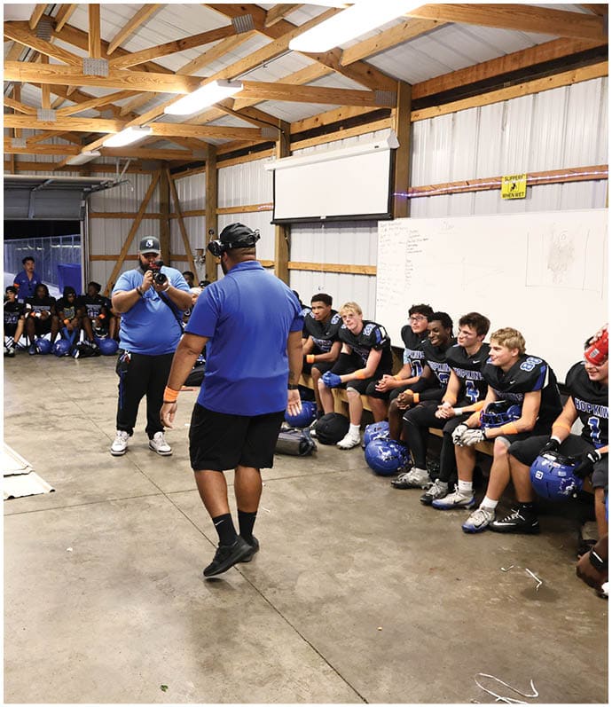 A group of football players wearing black and white uniforms. Description generated by AI