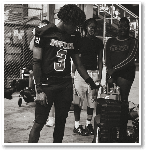 Two football players wearing black jerseys with the number 11 on them. Description generated by AI