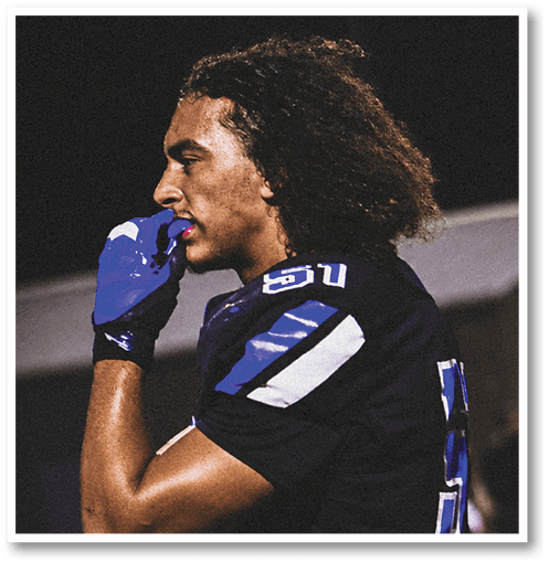 A football player wearing a black jersey with the number 6 on it. Description generated by AI