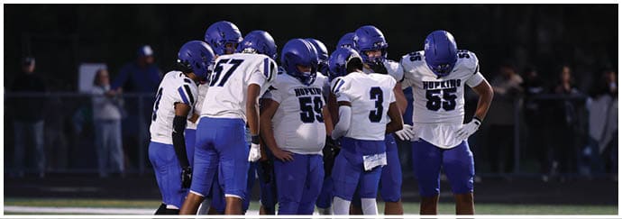 A group of football players on a field. Description generated by AI