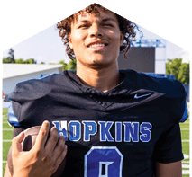 A young man wearing a white jersey with the number 10 on it. Description generated by AI