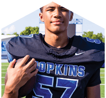A young man wearing a white jersey with the number 10 on it. Description generated by AI