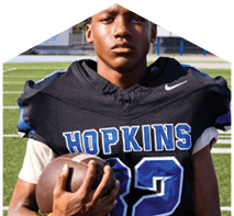 A young man wearing a white jersey with the number 10 on it. Description generated by AI