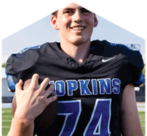 A young man wearing a white jersey with the number 10 on it. Description generated by AI