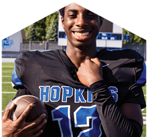 A young man wearing a white jersey with the number 10 on it. Description generated by AI