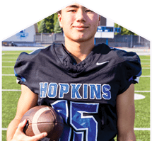 A young man wearing a white jersey with the number 10 on it. Description generated by AI