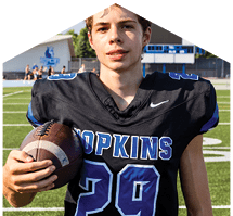 A young man wearing a white jersey with the number 10 on it. Description generated by AI