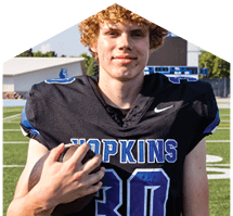 A young man wearing a white jersey with the number 10 on it. Description generated by AI