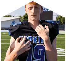 A young man wearing a white jersey with the number 10 on it. Description generated by AI