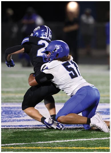 A football player wearing a blue jersey with the number 58 on it. Description generated by AI