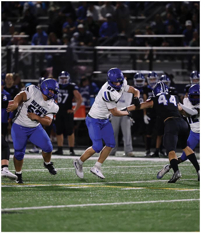 A group of football players wearing black and white uniforms. Description generated by AI