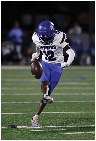 A football player running on the field. Description generated by AI