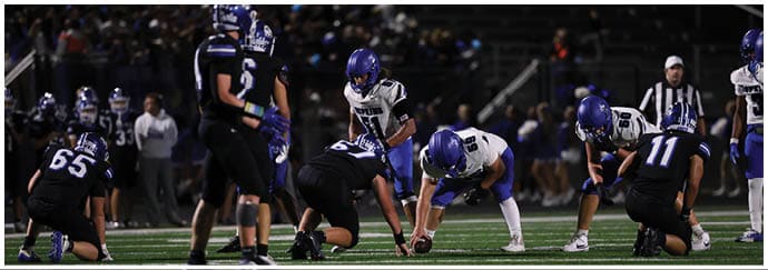 A group of football players on a field. Description generated by AI