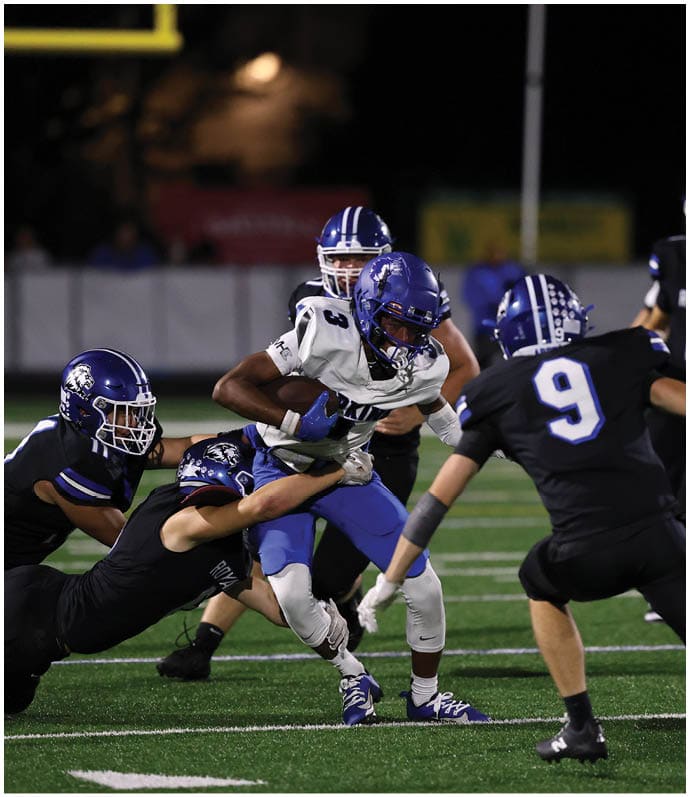 A group of football players wearing black and white uniforms. Description generated by AI