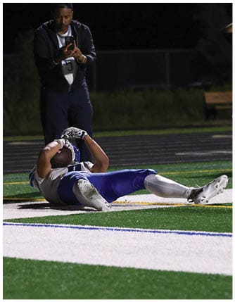 A football player running on the field. Description generated by AI