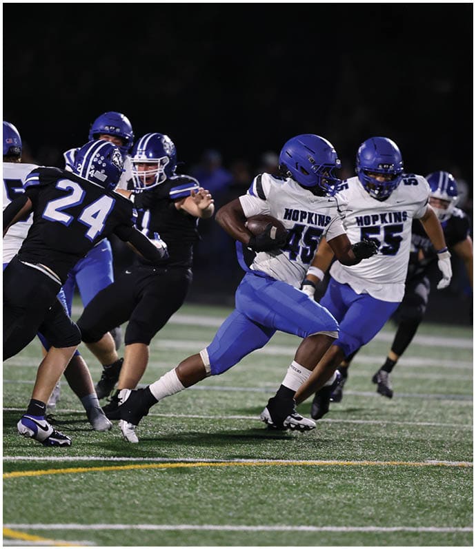A group of football players wearing black and white uniforms. Description generated by AI