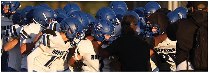 A group of football players on a field. Description generated by AI