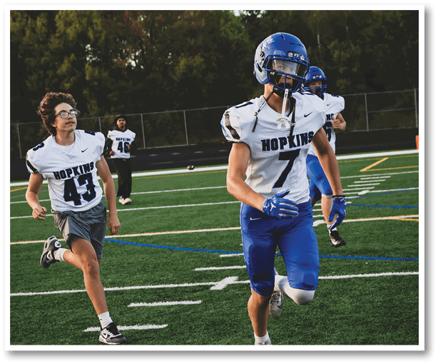A group of football players wearing black jerseys with the number 3 on them. Description generated by AI
