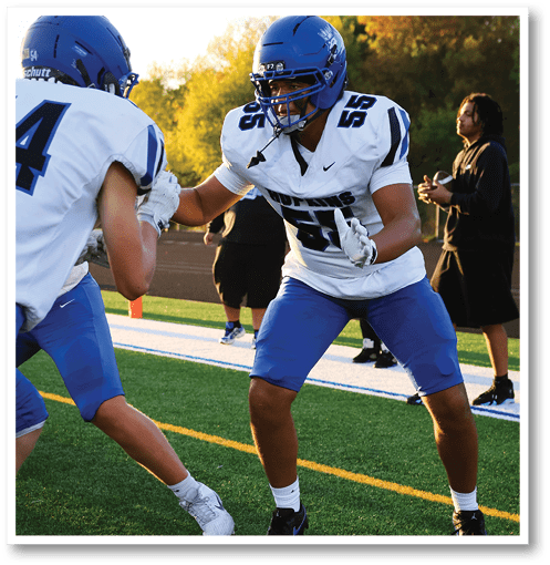 Two football players wearing black jerseys with the number 11 on them. Description generated by AI