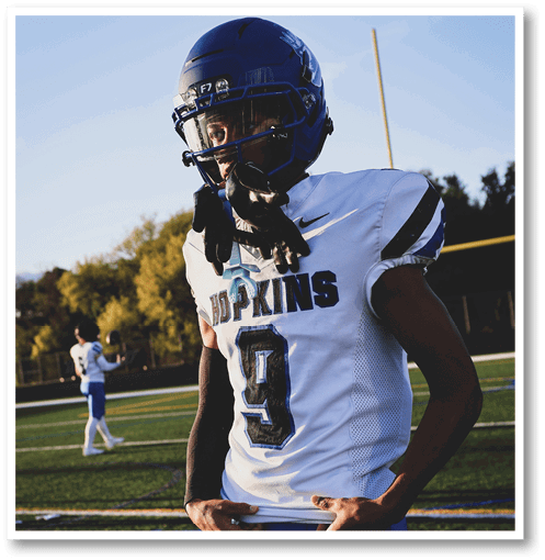 A football player wearing a black jersey with the number 6 on it. Description generated by AI