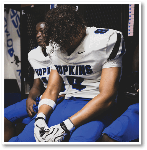 A football player wearing a black jersey with the number 6 on it. Description generated by AI