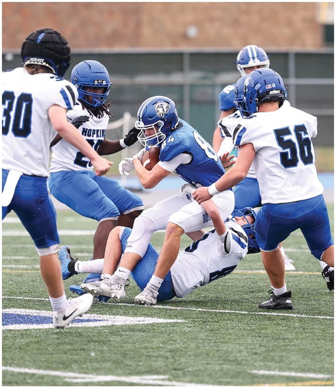 A group of football players wearing black and white uniforms. Description generated by AI