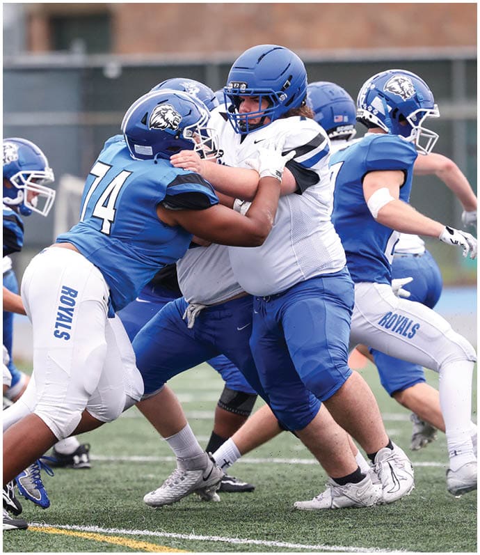 A group of football players wearing black and white uniforms. Description generated by AI