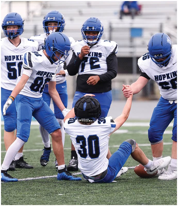 A group of football players wearing black and white uniforms. Description generated by AI