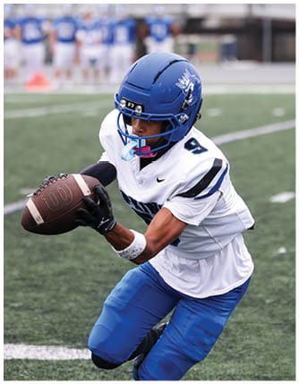 A football player running on the field. Description generated by AI