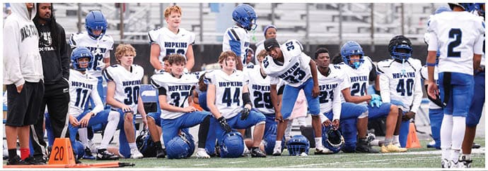 A group of football players on a field. Description generated by AI