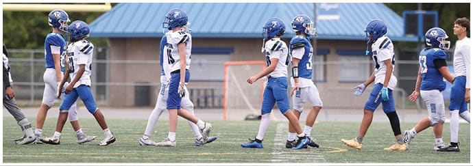 A group of football players on a field. Description generated by AI