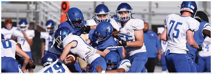 A group of football players on a field. Description generated by AI